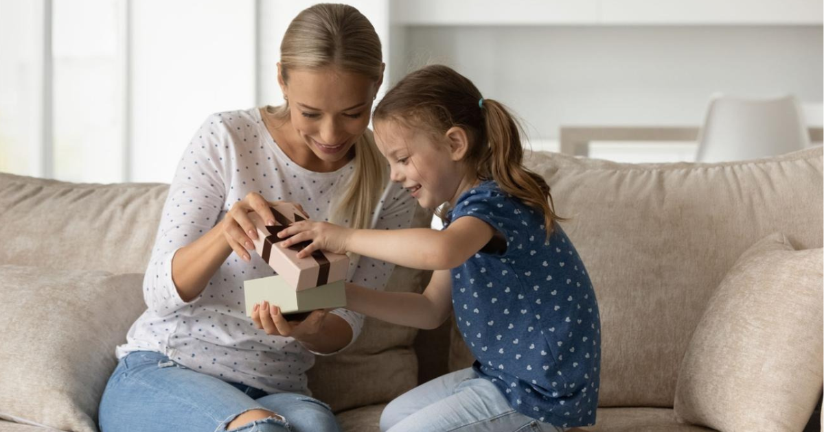Mom opening a personalized gift from her child.